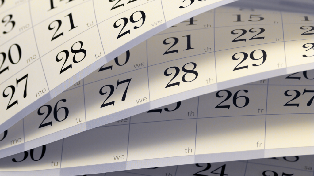 An image of several months of a calendar out on a desk.